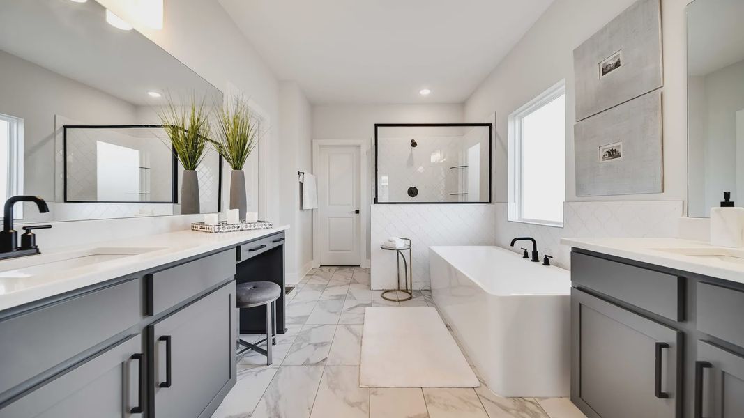 Indulge in elegance with marble flooring and sleek gray cabinetry in Richvale Estates' exquisite bathroom.