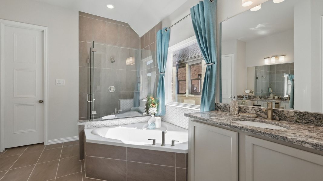 Elegant tub, glass shower, and granite counter enhance this Green Oaks Preserve bathroom's opulence. Elegant tub, glass shower, and granite counter enhance this Green Oaks Preserve bathroom's opulence.