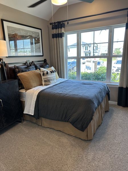 Cozy bedroom with neutral tones, large window, stylish curtains, and modern artwork above the bed. Cozy bedroom with neutral tones, large window, stylish curtains, and modern artwork above the bed.