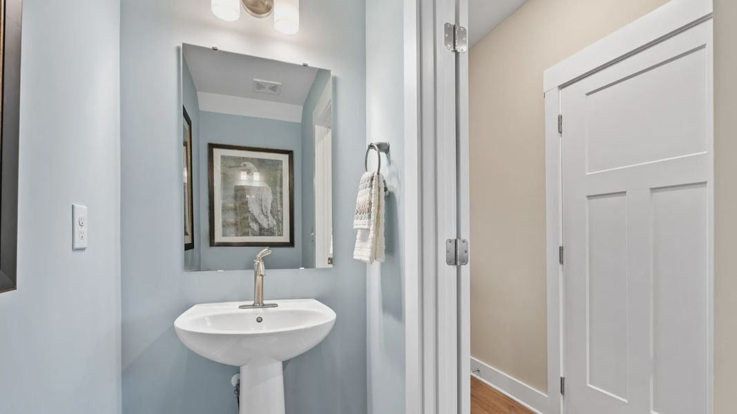 Blue accented half bathroom in two story townhome at Saluda Crossing by DRB Homes in Piedmont, SC
