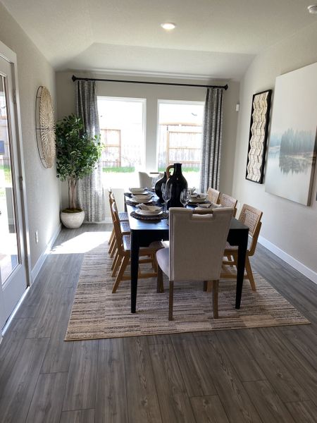 A bright dining room with a sleek table, modern chairs, large windows, and elegant décor. A bright dining room with a sleek table, modern chairs, large windows, and elegant décor.