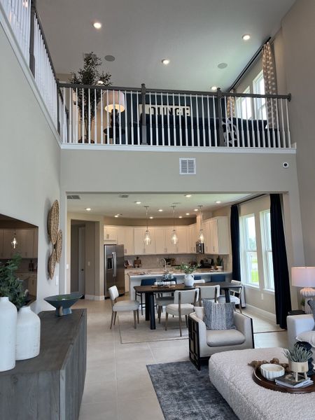 A modern open-concept living area with a loft, featuring elegant decor, a sleek kitchen, and cozy seating. A modern open-concept living area with a loft, featuring elegant decor, a sleek kitchen, and cozy seating.