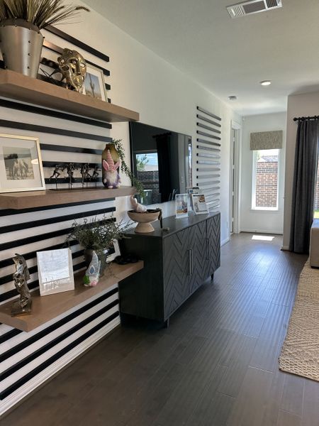 A modern room featuring decorative shelves, stylish wall accents, and a sleek storage cabinet. A modern room featuring decorative shelves, stylish wall accents, and a sleek storage cabinet.