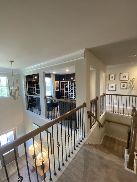 A sophisticated interior with elegant railing, modern art, and ample natural light, offering a chic and inviting ambiance.