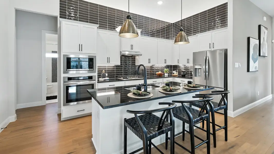 Bright modern kitchen with a large island, stainless steel appliances, and elegant designer finishes. Bright modern kitchen with a large island, stainless steel appliances, and elegant designer finishes.