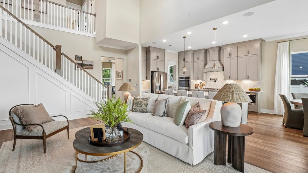 Gathering room with high ceilings, bright natural lighting from windows, and view of kitchen Gathering room with high ceilings, bright natural lighting from windows, and view of kitchen