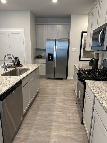 A modern kitchen with granite countertops, stainless steel appliances, and sleek cabinetry for a contemporary feel.