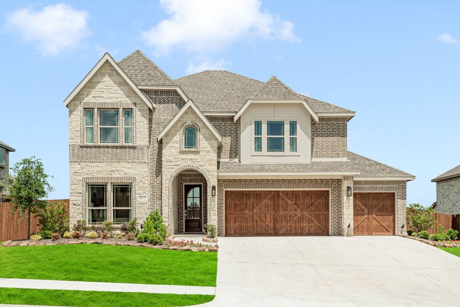 Two-story brick and stone home with arched entry, three-car garage, and manicured front lawn Two-story brick and stone home with arched entry, three-car garage, and manicured front lawn