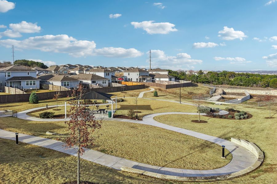 A large green field with buildings in the background.