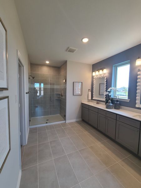 A sleek bathroom with a spacious glass shower, dual vanity, and chic lighting for a modern touch.