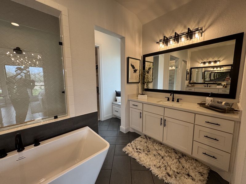 A luxurious bathroom featuring a sleek white bathtub, elegant vanity, and chic lighting for a modern spa-like retreat. A luxurious bathroom featuring a sleek white bathtub, elegant vanity, and chic lighting for a modern spa-like retreat.