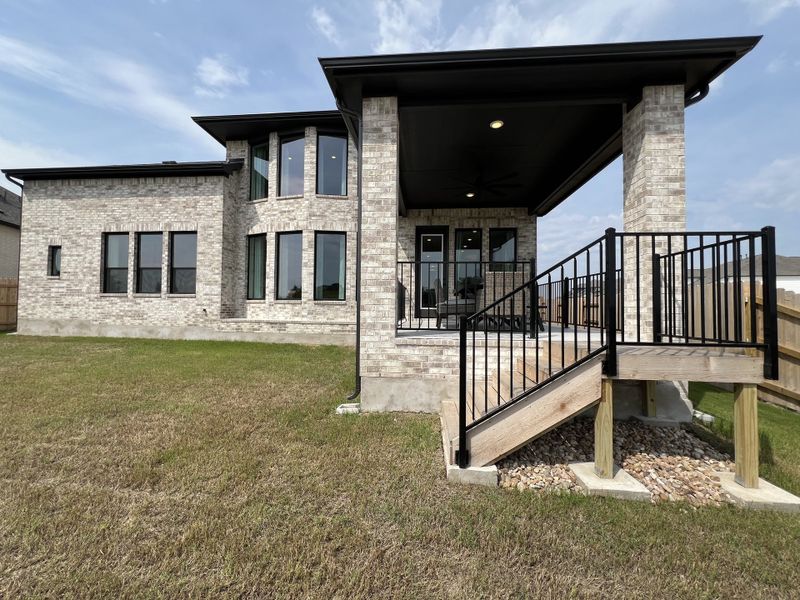Elegant brick home with modern windows and a raised patio in Flora - 60' by Westin Homes (Hutto, TX).