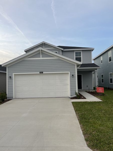 A modern gray two-story home with a spacious driveway in Marion Ranch: Marion Ranch 40's by Lennar (Ocala, FL).