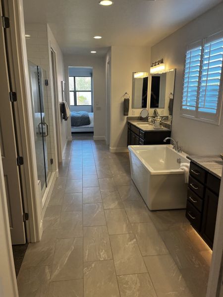 A spacious bathroom with a freestanding tub, double vanity, and a walk-in shower.