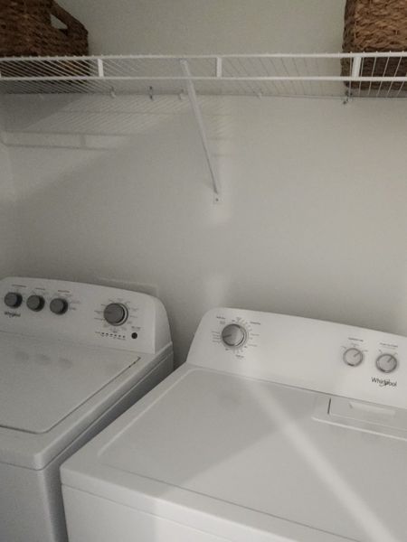 A functional laundry space featuring modern appliances and sleek shelving for easy organization.