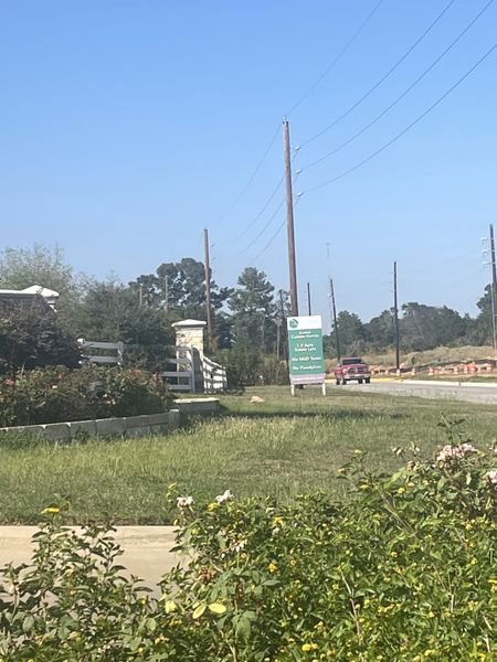 Scenic community entrance with lush greenery in Tealpointe Lake Estates by Jamestown Estate Homes (Tomball, TX).