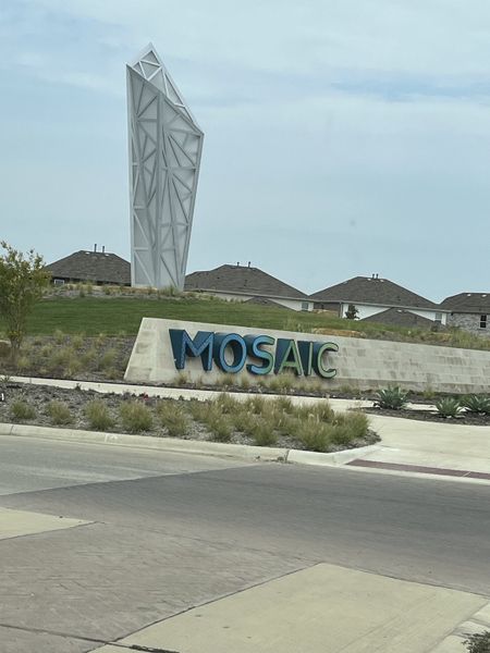 A modern entrance with a striking sculpture welcomes you to Mosaic 50' by Perry Homes in Celina, TX.