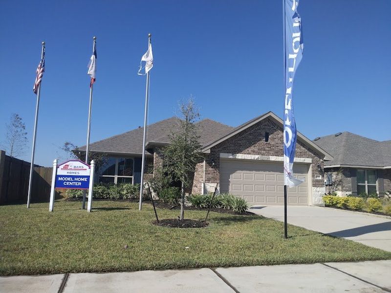 A beautifully landscaped model home with a welcoming entryway in Cobblestone by Adams Homes, highlighted by elegant brickwork.