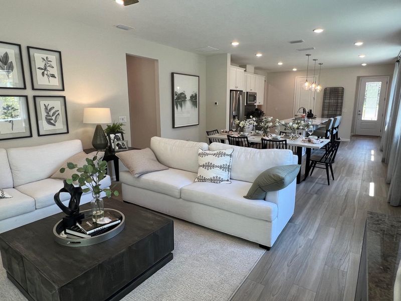 A modern open-concept living area with cozy seating, elegant dining space, and a stylish kitchen.