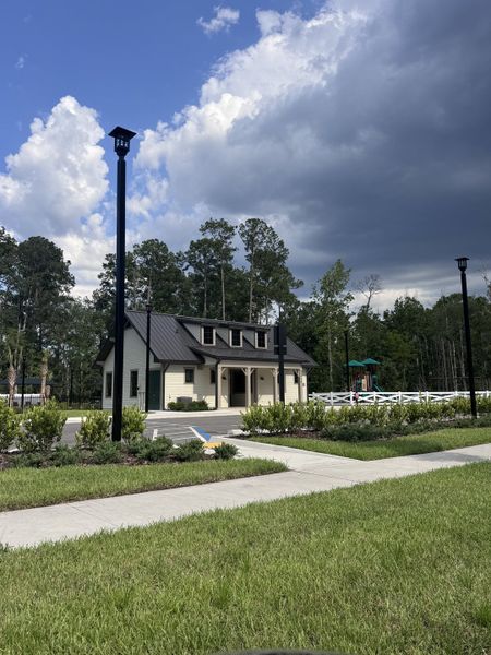 A quaint community building with a dark roof and lush landscaping in Jennings Farm by LGI Homes (Middleburg, FL).