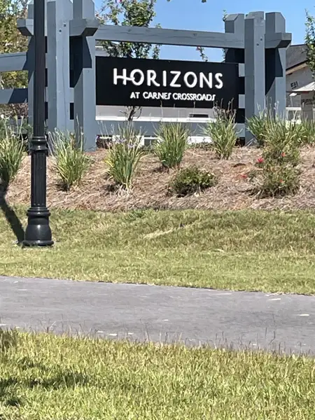 A welcoming entrance sign for Horizons at Carnes Crossroads by Lennar, set amidst landscaped greenery in Summerville, SC.