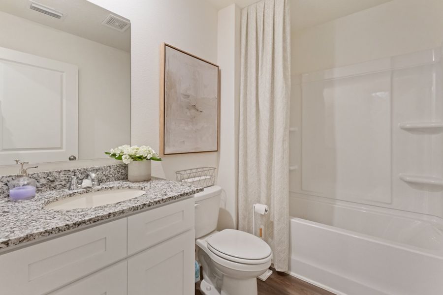 A bathroom with a tub sink and toilet.