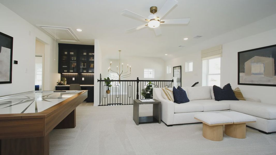 Luxurious open living area with chic black cabinetry, plush white seating, and ambient lighting in The Woodlands Hills.
