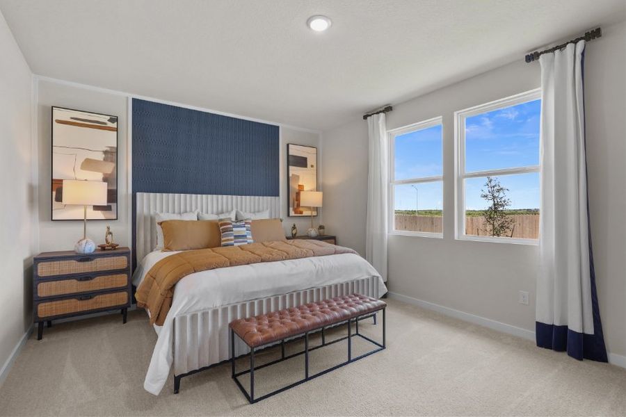 A bedroom with a bed and a bench.