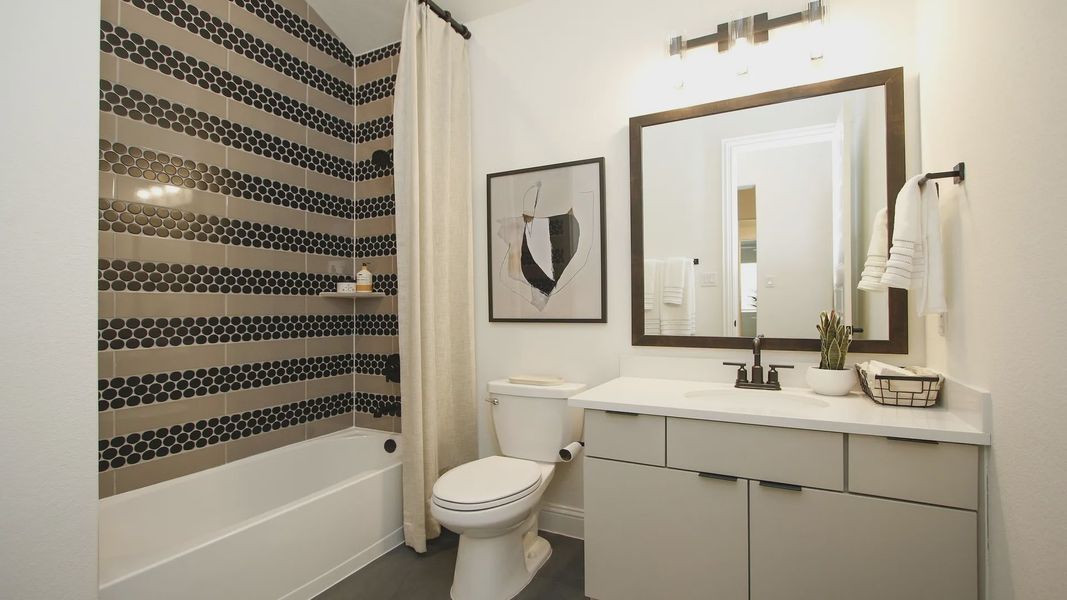 Experience opulence with striking black hexagon tiles and sleek fixtures in The Woodlands Hills.