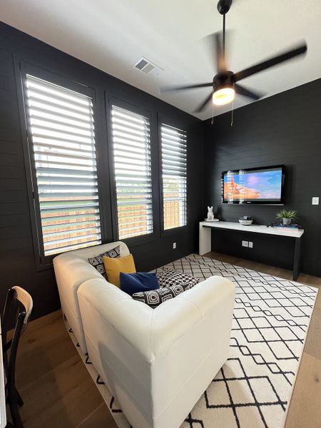 A cozy living area featuring a modern white couch, patterned rug, and sleek ceiling fan, perfect for relaxing and entertaining. A cozy living area featuring a modern white couch, patterned rug, and sleek ceiling fan, perfect for relaxing and entertaining.