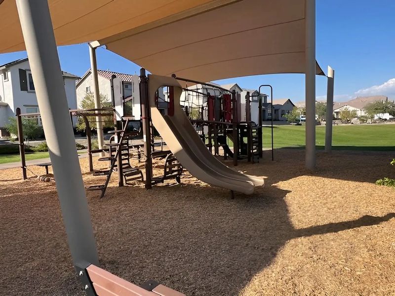 A family-friendly playground with covered play equipment in Los Cielos at Rancho Mercado by Taylor Morrison (Surprise, AZ).