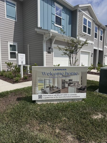 Modern townhome with blue accents and landscaped yard in Longbay Townhomes by Lennar (Middleburg, FL).
