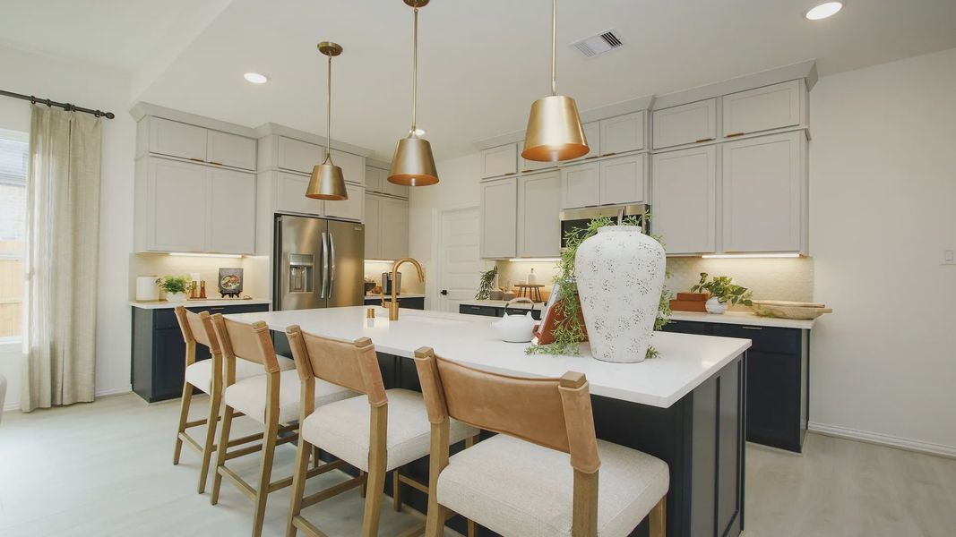 Elegant kitchen with quartz countertops, luxe pendant lighting, and custom cabinetry in The Woodlands Hills.