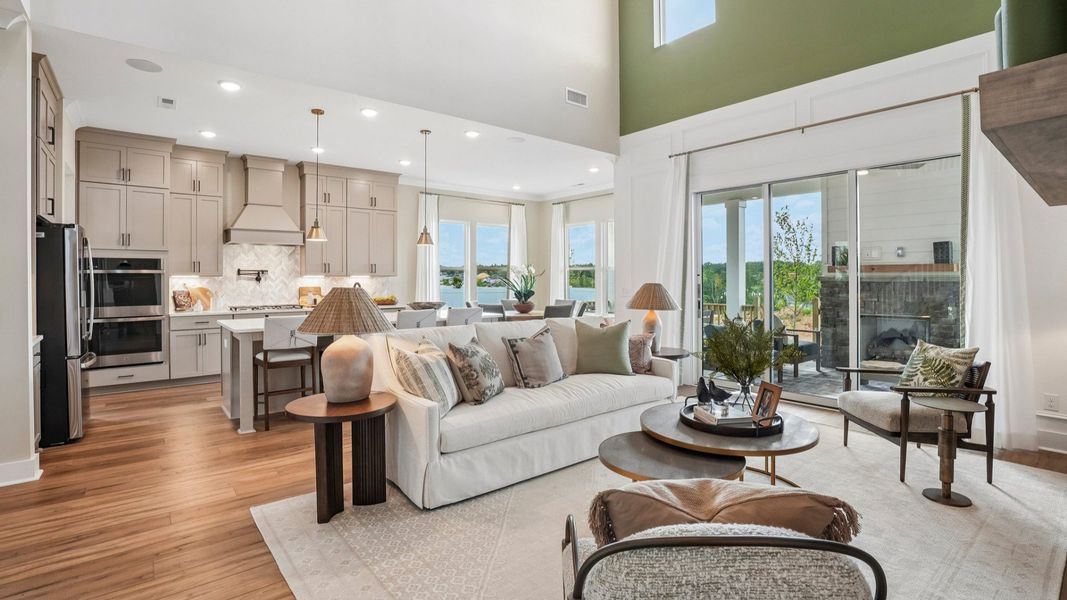 Gathering room with high ceilings, bright natural lighting from windows, and view of kitchen Gathering room with high ceilings, bright natural lighting from windows, and view of kitchen