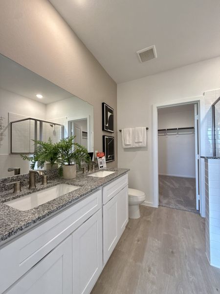 A modern bathroom featuring a granite double vanity, sleek fixtures, and natural accents with elegant tile flooring. A modern bathroom featuring a granite double vanity, sleek fixtures, and natural accents with elegant tile flooring.
