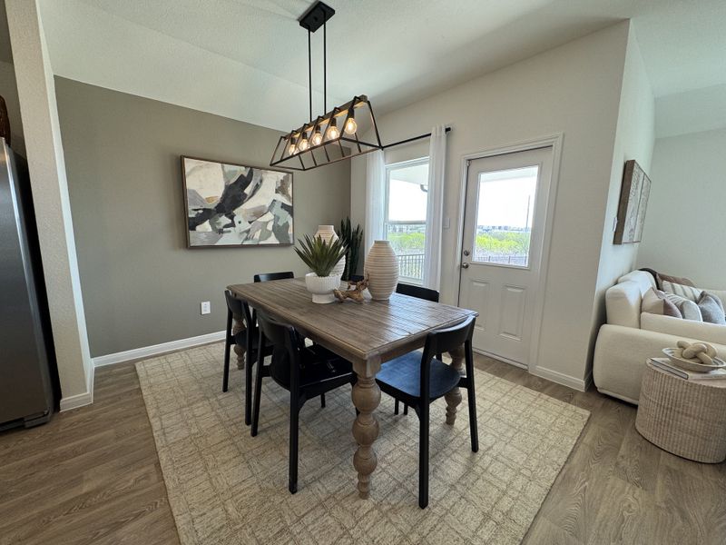 A cozy dining area with a modern chandelier, wooden table, and abstract art. Bright and welcoming with a neutral palette. A cozy dining area with a modern chandelier, wooden table, and abstract art. Bright and welcoming with a neutral palette.