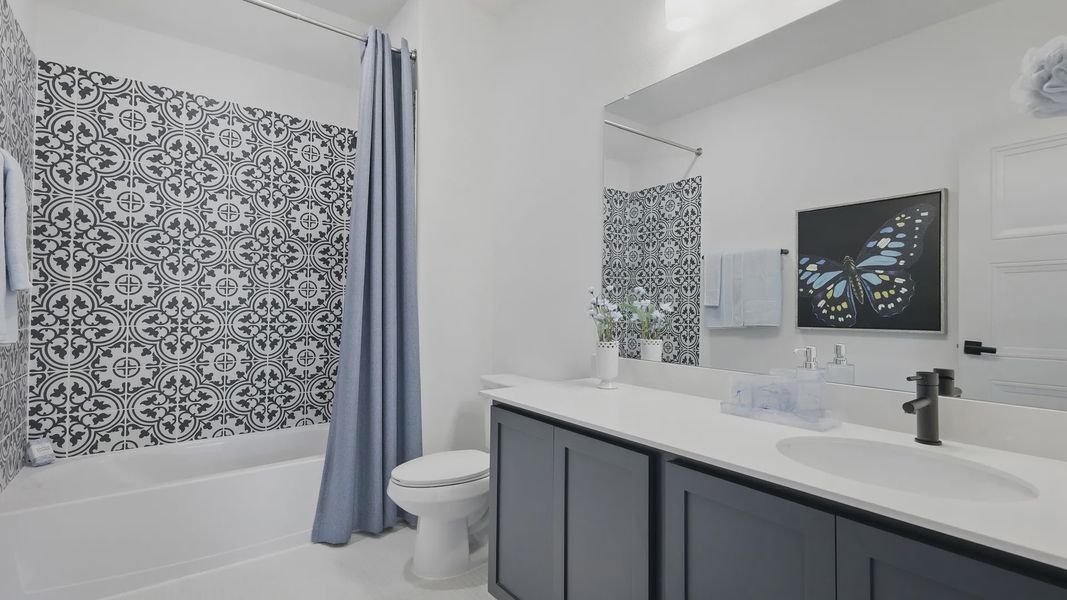Luxurious bathroom with black vanity, striking patterned tiles, and refined blue accents in Westridge.