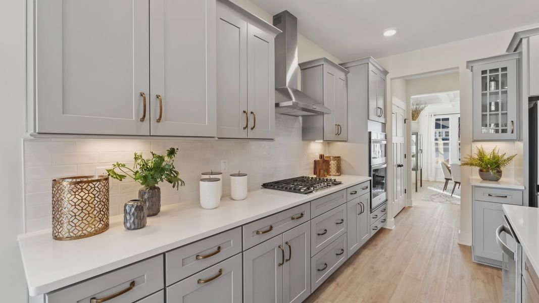 Modern kitchen with gold accents and light gray cabinetry giving a luxury feel at Fox Hollow by DRB Homes in Spartanburg, SC