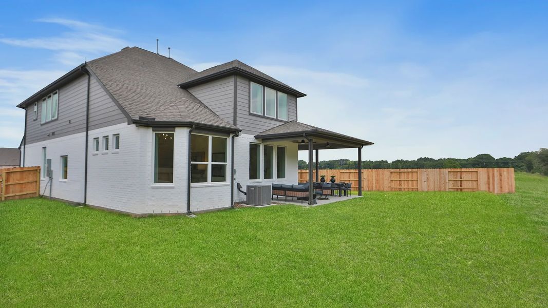 Elegant Katy Lakes residence featuring a spacious covered patio and expansive, manicured lawn. Elegant Katy Lakes residence featuring a spacious covered patio and expansive, manicured lawn.