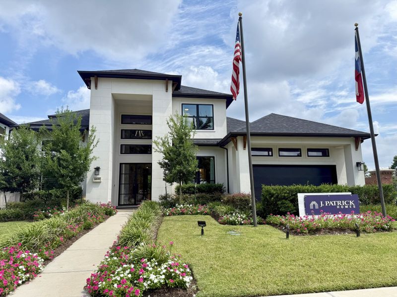 A modern white home with a manicured lawn and vibrant flowers in Sienna 70' Lots by J. Patrick Homes (Missouri City, TX). A modern white home with a manicured lawn and vibrant flowers in Sienna 70' Lots by J. Patrick Homes (Missouri City, TX).