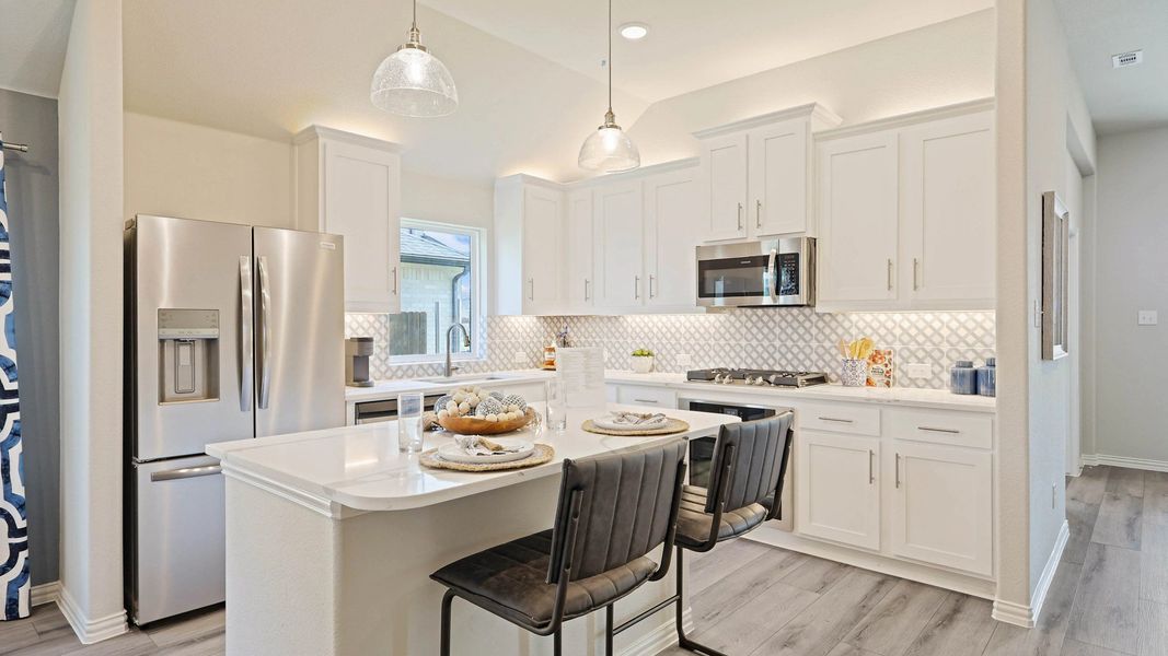 Elegant Pebblebrook kitchen boasts sleek white cabinetry and premium stainless steel appliances.