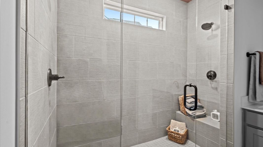 Notable primary bath featuring frameless tiled walk-in shower and tasteful design touches throughout Notable primary bath featuring frameless tiled walk-in shower and tasteful design touches throughout