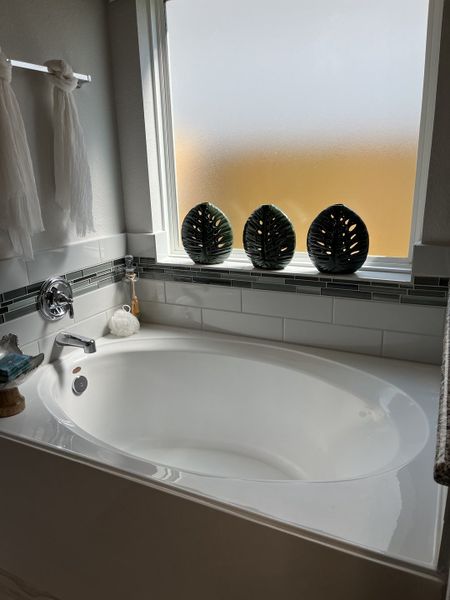 A cozy bathroom featuring a sleek bathtub, frosted window, and modern tile accents. A cozy bathroom featuring a sleek bathtub, frosted window, and modern tile accents.