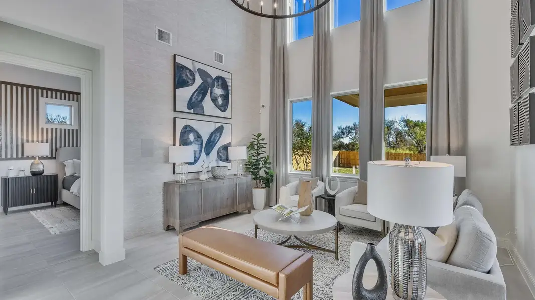 Expansive windows and soaring ceilings define this luxurious Creeks Crossing living space, emphasizing elegance.