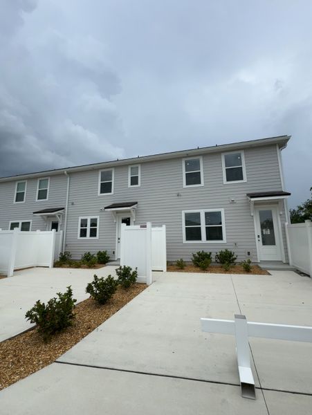 Modern townhouse with a sleek facade and manicured yard in RiverTown - Meadows by Mattamy Homes (St. Johns, FL).