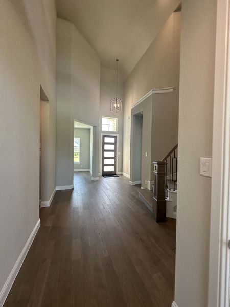 A spacious entryway with high ceilings, sleek hardwood floors, and elegant lighting fixtures leading to an inviting interior. A spacious entryway with high ceilings, sleek hardwood floors, and elegant lighting fixtures leading to an inviting interior.