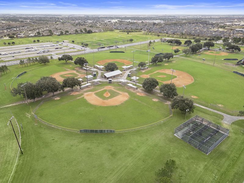 A large green field with buildings and trees. A large green field with buildings and trees.
