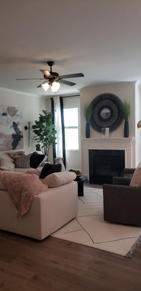 A cozy living room with plush seating, a central fireplace, and elegant decor in neutral tones.