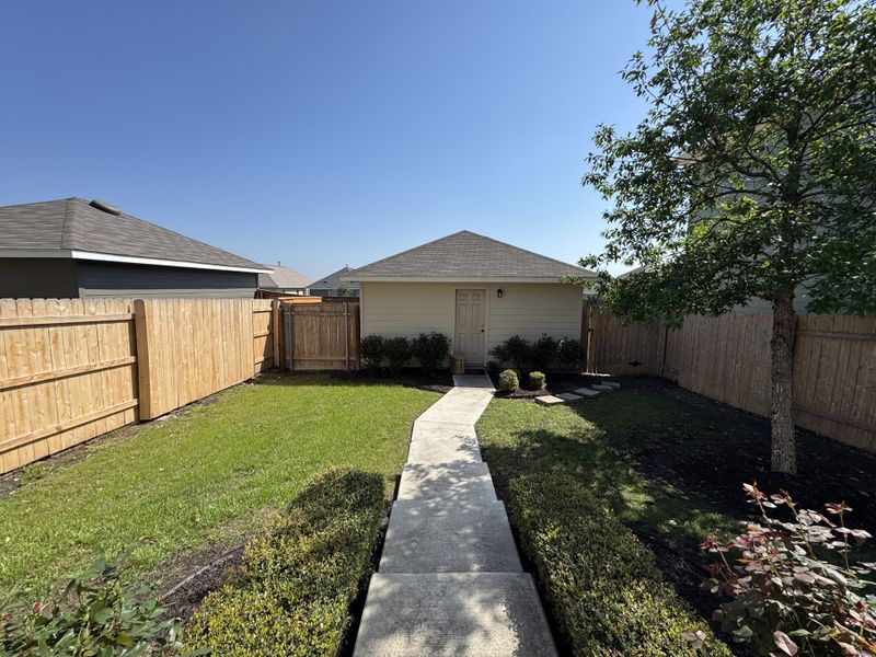 A quaint backyard with a manicured lawn and a cozy shed in Trace by Pacesetter Homes (San Marcos, TX). A quaint backyard with a manicured lawn and a cozy shed in Trace by Pacesetter Homes (San Marcos, TX).