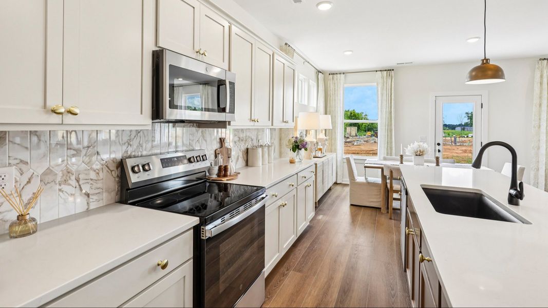 Kitchen with tile backsplash, pendant lighting, and quartz countertops